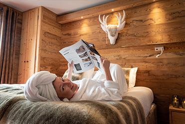 Jeune femme en peignoir dans une chambre double de l'hôtel Ski lodge Val d'Isère