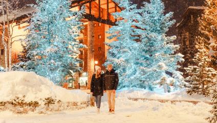 Jeune couple se baladant dans le village de Val d'Isère enneigé